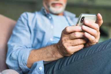 Foto van een man op leeftijd met een smartphone