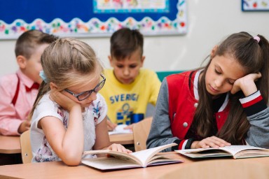 Foto van leerlingen die een boek aan het lezen zijn